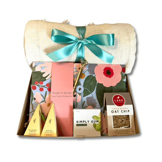 letter writing kit gift box featuring luxe letter writing set, linen throw, herbal tea, simply gum and oat chip cookie.